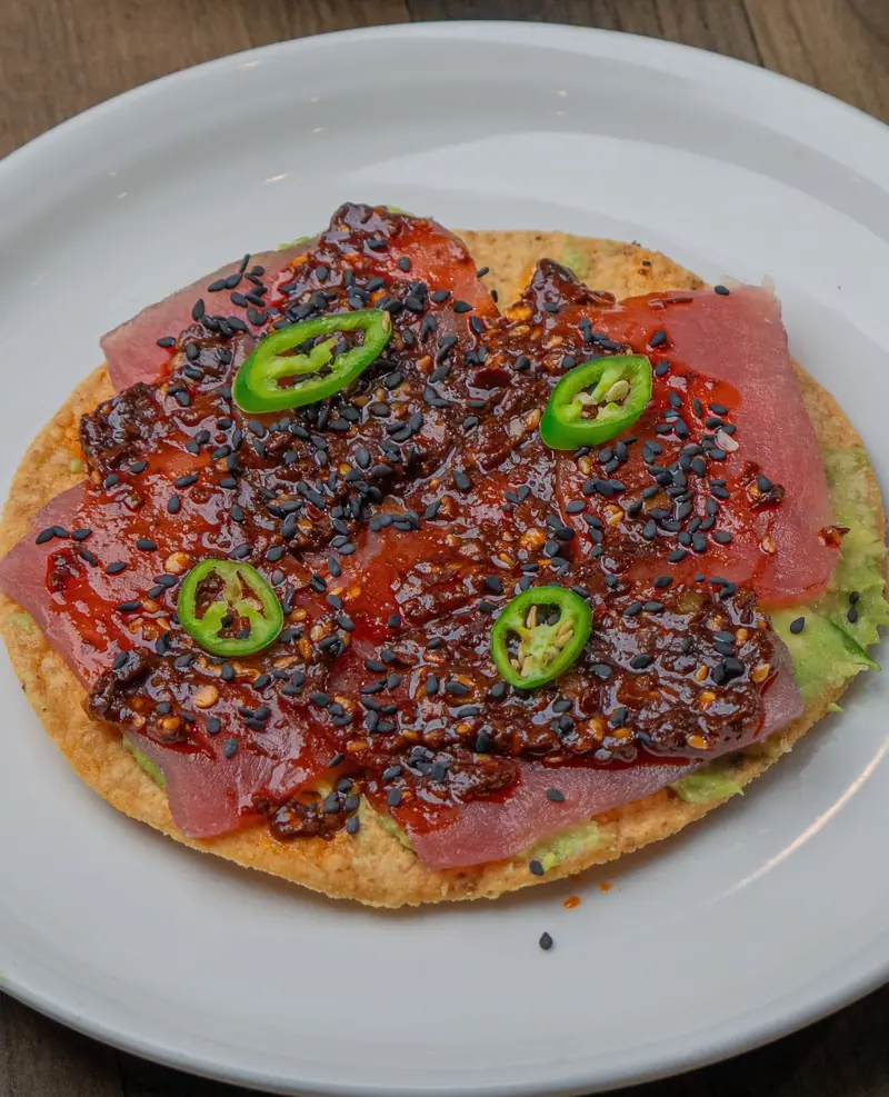 A tuna tostada with salsa macha and sliced jalapeño